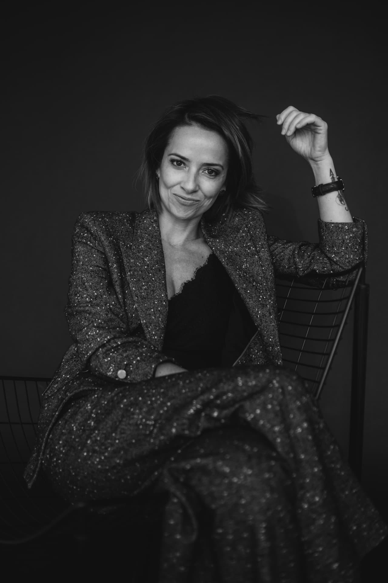 Retrato em preto e branco de Lara Titon sentada, olhando para a câmera